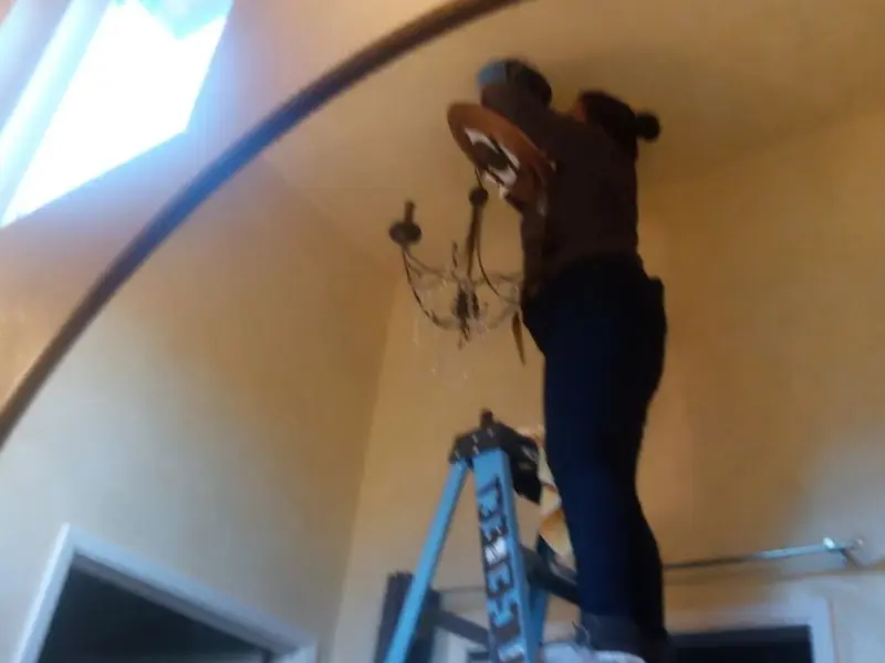 Electrician installing a chandelier in a Opp residence